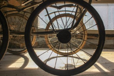 back wheels of my old baby carriage in the attic during sunset