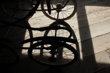 shadows of my old baby carriage in my attic wooden floor during sunset