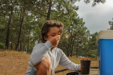 child in a pine forest enjoying a healthy snack in the evening