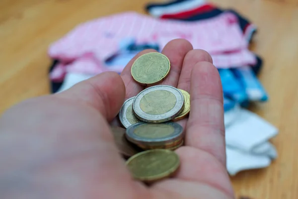 euro coins in the palm of the hand to pay for clothes