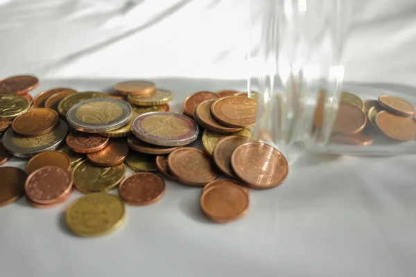 euro coins out of the glass jar for paying for invoices