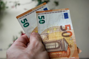 Hesabımdan tasarruf etmek için sol elimde iki euro var.