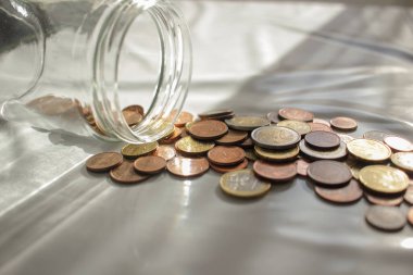Kriz zamanlarında harcamak için cam kavanozdan euro sikkelerimi alıyorum.