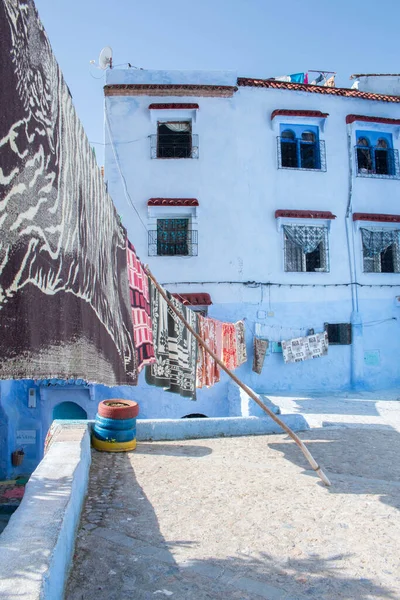 Fas 'ın başkenti Fas' ta güneşli bir günde tipik bir Fas evinin önünde asılı giysiler..