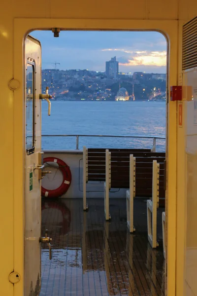 İstanbul 'da deniz taşımacılığı, gemi, yağmurlu bir günde ahşap koltuklar ve şehir manzarası.