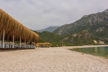 Türkiye 'nin Oludeniz kentindeki Blue Lagoon plajlarındaki estetik ve güzel sahil beldesi. Arka planda dağlar bulutlu bir günde. 