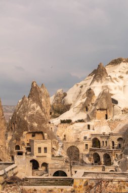 Türkiye 'nin Cappadocia kentindeki kayalıklardaki tipik evler, bulutlu bir günde, kışın.