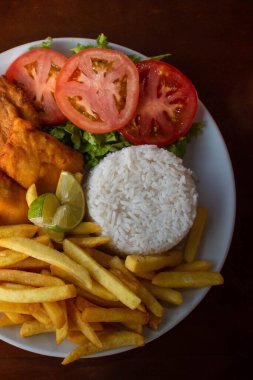 Tipik Brezilya kombinasyon tabağı, pilav, kızarmış balık, patates kızartması ve salata.. 