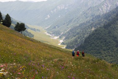 People hiking in the Caucasus mountain range. Mestia-Ushguli trekking, Georgia. 
