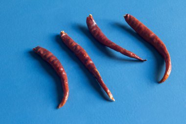 Mavi boyalı ahşap bir arka planda kurumuş ve susuz biberler. Yiyecek ve sebze.