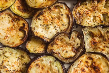 Üzerine sarımsak, fesleğen, biberli maydanoz ve tuz karışımı katılmış sulu fırında kavrulmuş patlıcan dilimleri. Ev yapımı ve sağlıklı tarifler..