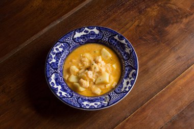 Güveçte morina balığı ve kırsal kestane ağacından yapılmış patatesle süslenmiş antika tabak. Balık ve sebzeli yemek tarifleri..