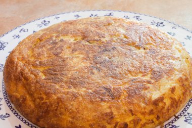 Dekoratif tabakta büyük bir patates omletinin yakın çekimi. Ev yapımı ve geleneksel yemekler..