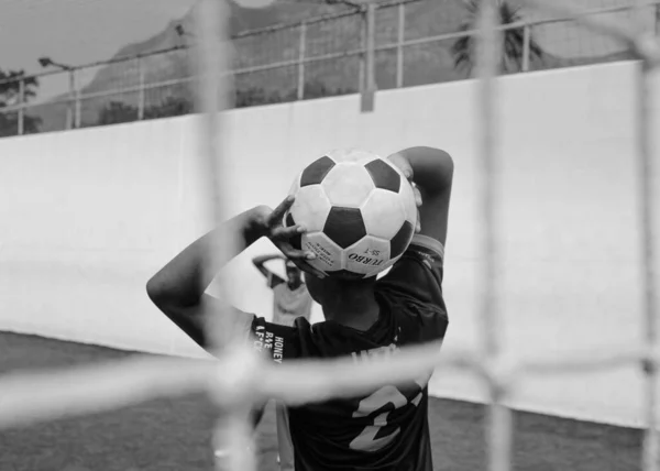 実行しているサッカー選手 サッカー選手を蹴るサッカー ゲーム 若いサッカー選手がボールを追いかけてします バック グラウンドでサッカー スタジアム — ストック写真
