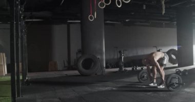 Sporcu adam spor salonunda temiz ve aptal halteri yapıyor.