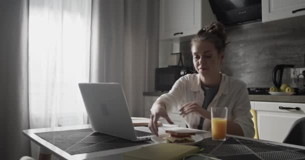 Mujer joven estudiando en la cocina — Vídeos de Stock