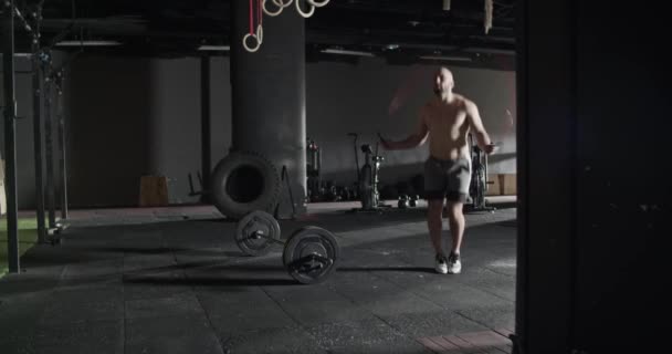 Spor salonunda idman yaparken ipten atlayan üstsüz sporcu. — Stok video