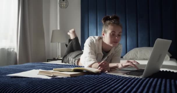 Studente femminile che utilizza il computer portatile sul letto — Video Stock