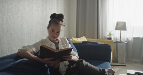 Pensive студент читає книгу і готується до іспитів — стокове відео