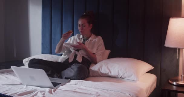 Mladá žena sleduje film v posteli — Stock video