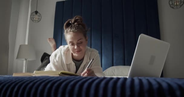Studente femminile che utilizza il computer portatile sul letto — Video Stock