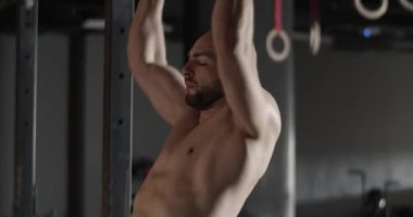 Antrenman sırasında barfiks çeken güçlü bir sporcu.