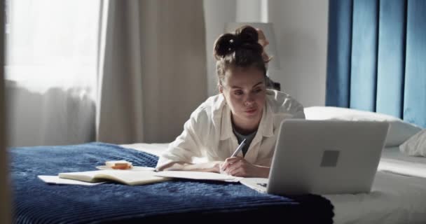 Studente femminile che utilizza il computer portatile sul letto — Video Stock
