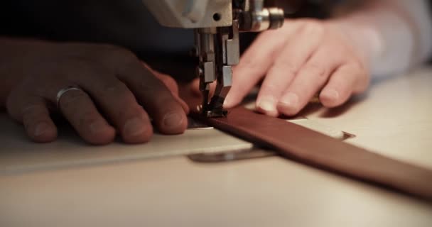 Stříhaný řemeslník šití koženého opasku — Stock video