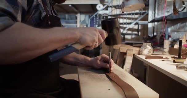 Řemeslník děrování otvory na opasku — Stock video