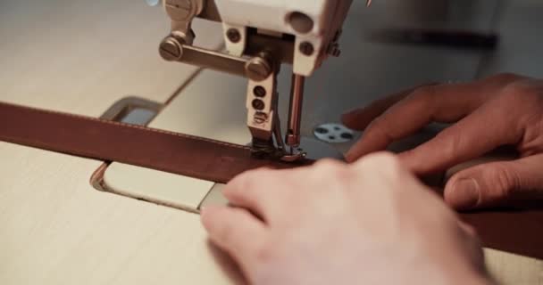 Stříhaný řemeslník šití koženého opasku — Stock video