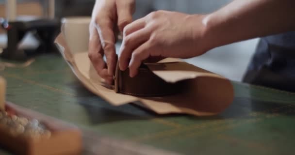 Männliche Kunsthandwerker wickeln Handarbeit auf Tisch — Stockvideo