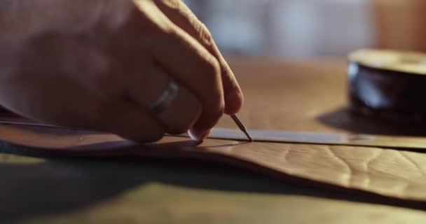 Männlicher Kunsthandwerker zeichnet Linie auf Leder — Stockvideo