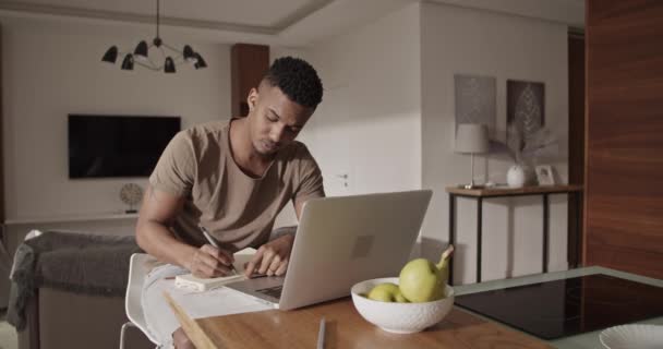 Черный фрилансер использует ноутбук для работы — стоковое видео