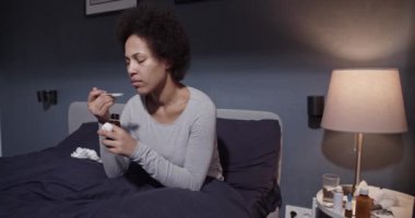 Afro-Amerikalı kadın ilaç alıyor.