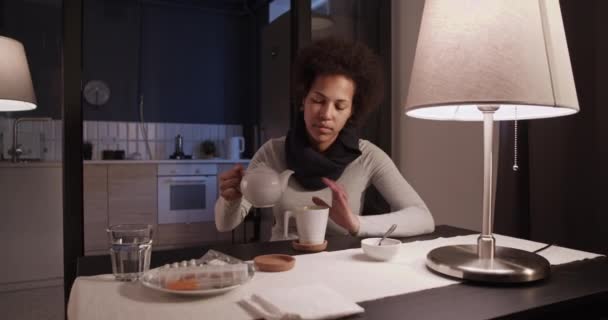 Хвора чорна жінка наливає чай — стокове відео