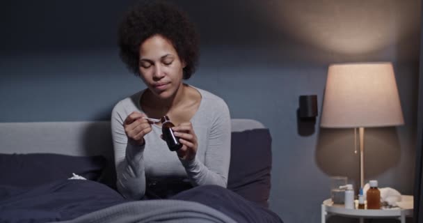 Mujer tomando medicamentos en la cama — Vídeo de stock