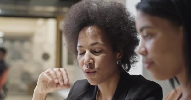Zwarte vrouw die gegevens op tablet aan collega laat zien — Stockvideo