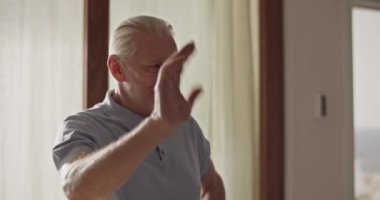 Yetişkin oğul hediye paketi getiriyor ve büyük babayı selamlıyor.