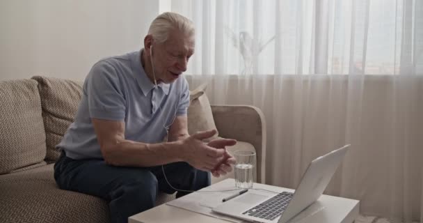Pensionär Viftar Hand Och Talar Med Online Släktingar Laptop — Stockvideo