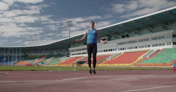 Stadyumda Atlama Ipiyle Egzersiz Yapan Genç Bir Sporcu — Stok video