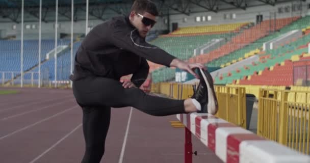 Sportsman Holding Leg Hurdle Stretching Workout Arena — Video