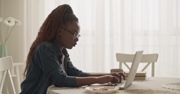 白天在家学习时 黑人妇女在上网本键盘上打字 — 图库视频影像