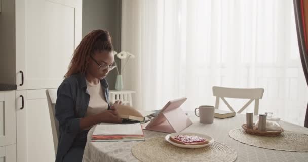 Молода Чорна Жінка Шукає Дані Книзі Під Час Навчання Вдома — стокове відео