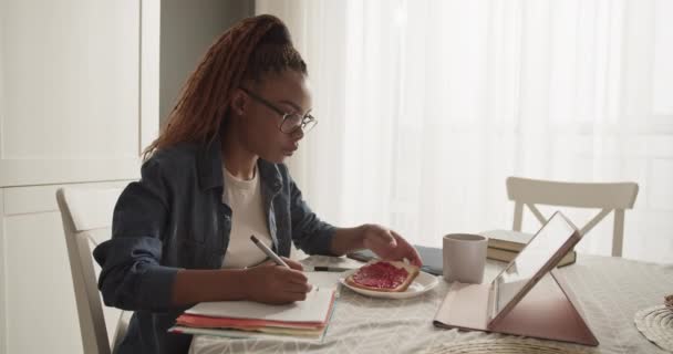 Mulher Negra Comendo Torradas Bebendo Café Enquanto Escreve Dados — Vídeo de Stock