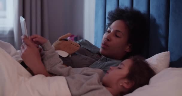 Різноманітна Мама Дитина Грають Гру Планшеті Розмовляють Ліжку Вночі — стокове відео