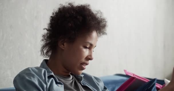 Black Mom Caressing Focused Kid Drawing Paper Sofa Home — Stock Video