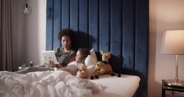 Чорна Мама Грає Гру Планшеті Дочкою Під Час Охолодження Ліжку — стокове відео