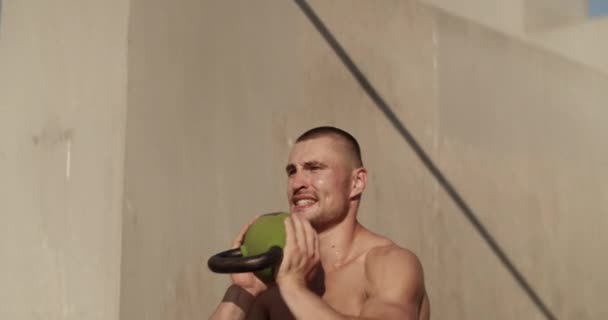 Muscular Male Athlete Doing Kettlebell Goblet Squats City Street — Stockvideo