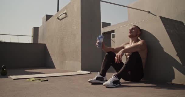 Weary Athlete Drinking Water Panting While Sitting Wall — 图库视频影像