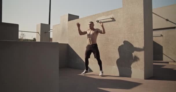 Atlet Melakukan Jumping Jacks Dekat Dinding Beton Selama Pelatihan Aerobik — Stok Video